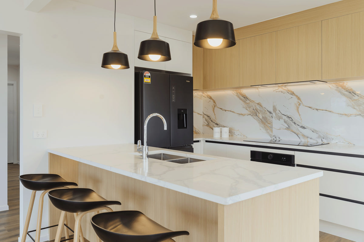 Kitchen island with marble-look benchtop and three pendant lights